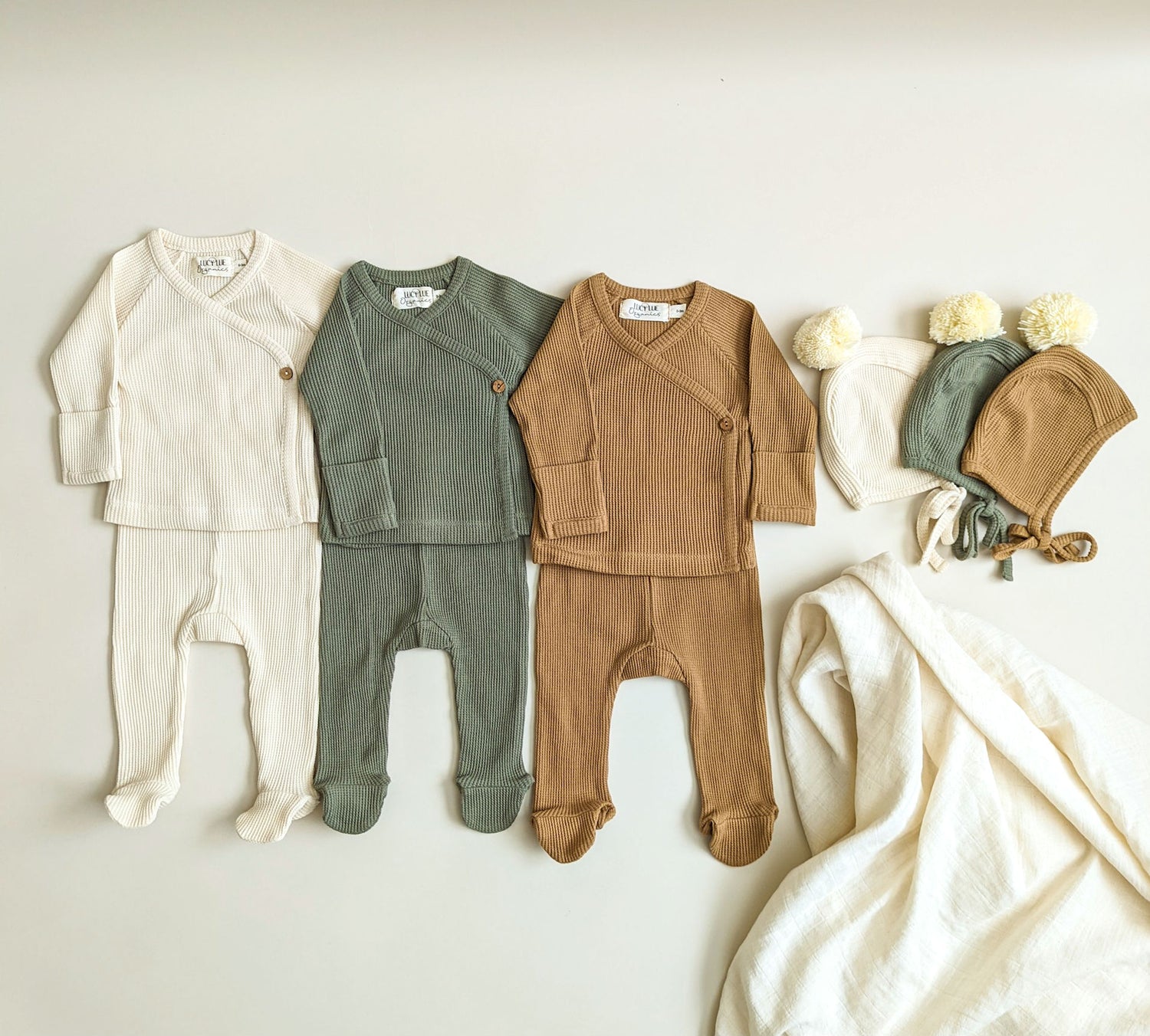 Newborn essentials and outfits including swaddles and two-piece kimono baby set in neutral colors